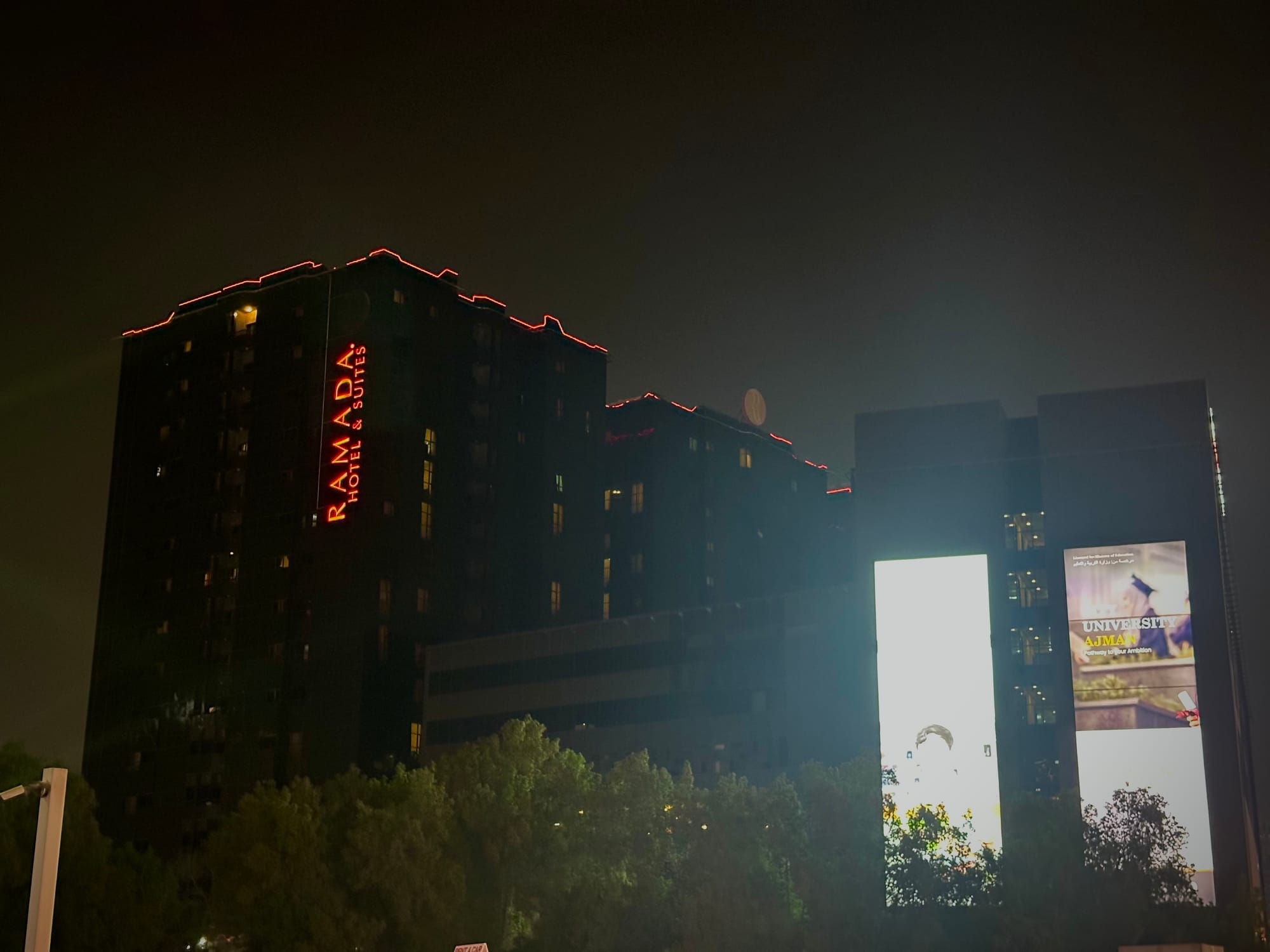 A nighttime view of the Ajman Ramada Hotel & Suites, known to local taxi drivers as "The Black Ramada".
