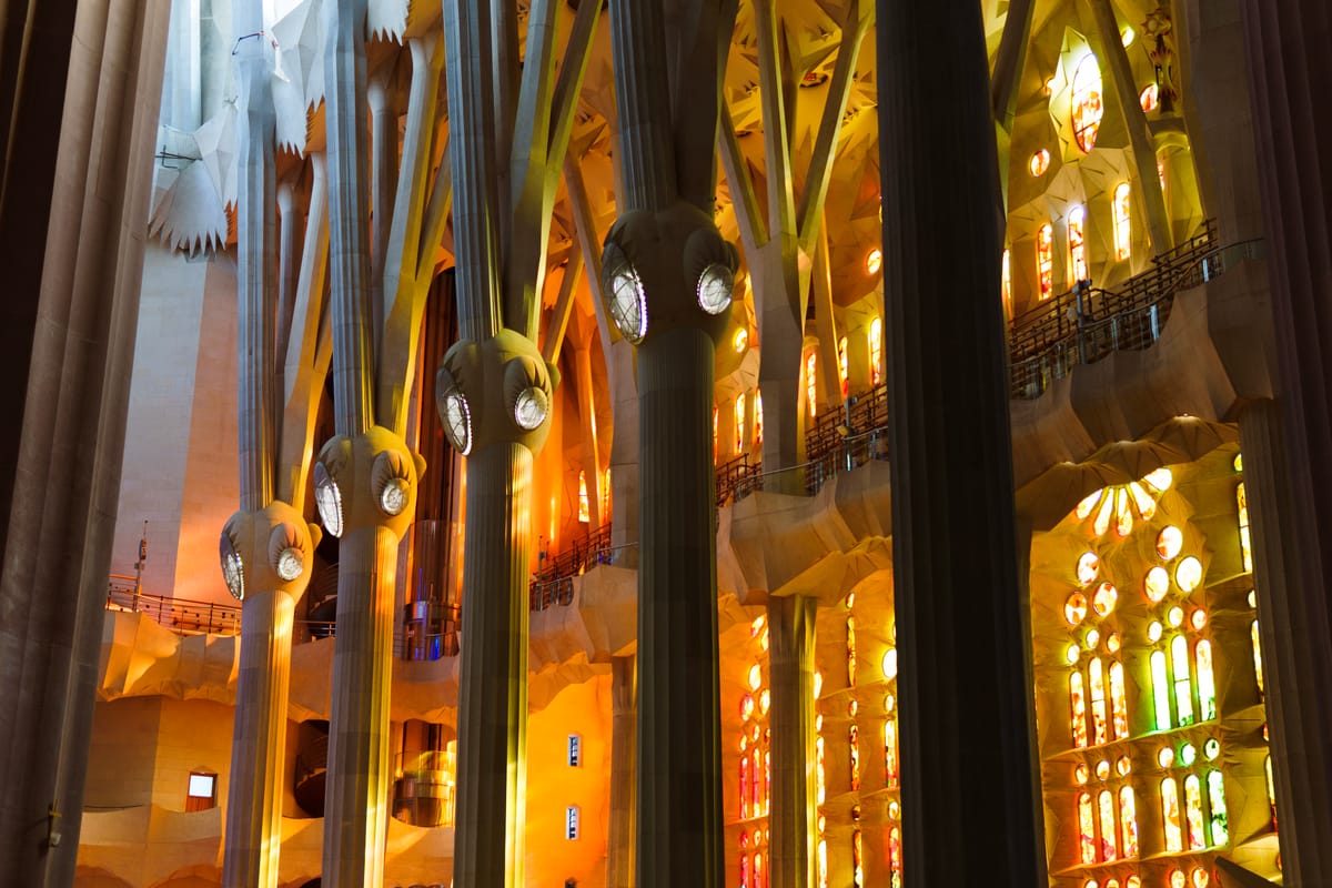 The west windows of the Sagrada Família, lit up in the afternoon, viewed from the interior.